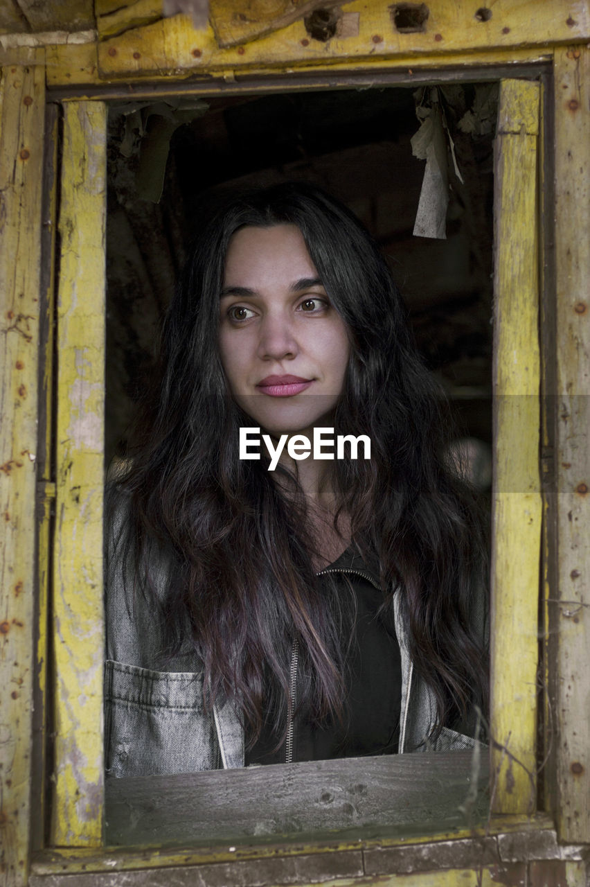 PORTRAIT OF YOUNG WOMAN IN OLD ABANDONED BUILDING