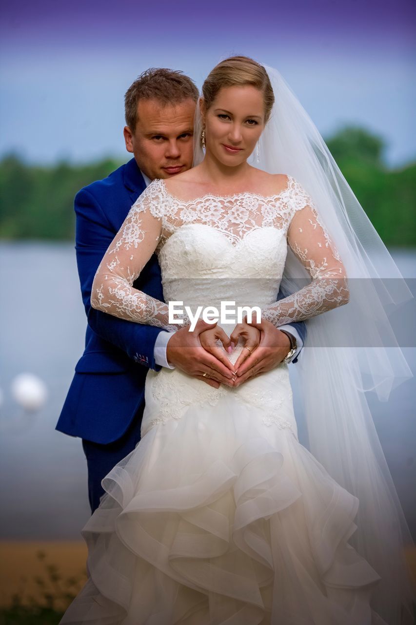 Portrait of smiling young couple making heart shape