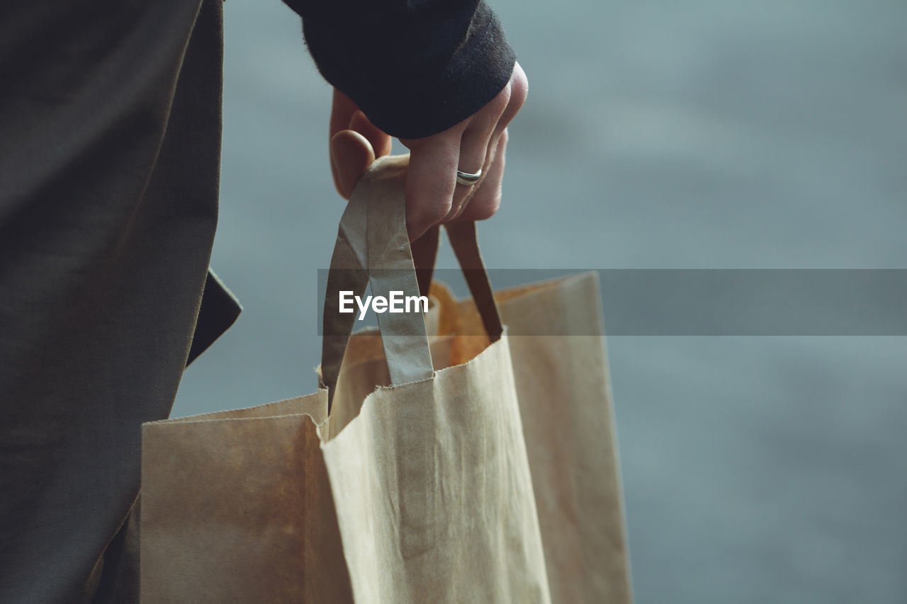 Midsection of person holding shopping bag