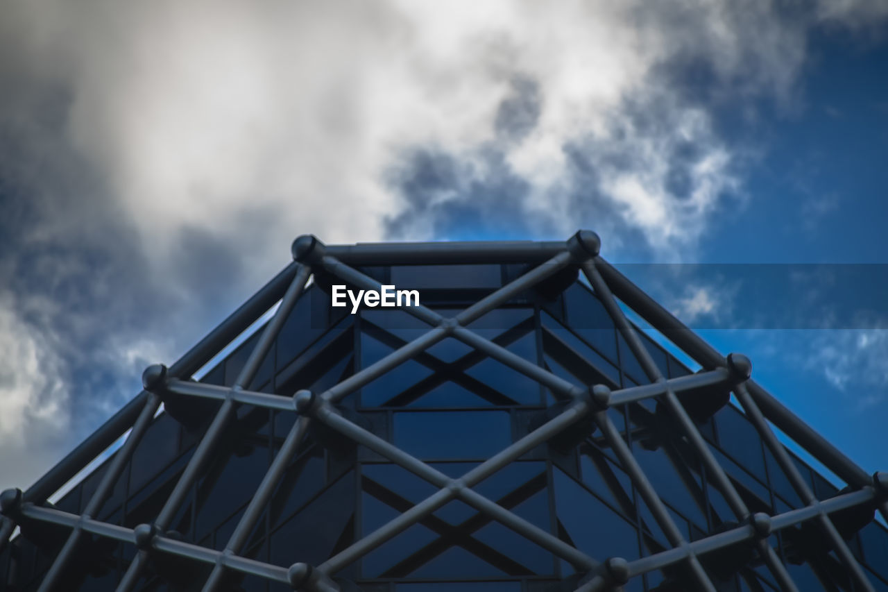 LOW ANGLE VIEW OF OFFICE BUILDING AGAINST CLOUDY SKY