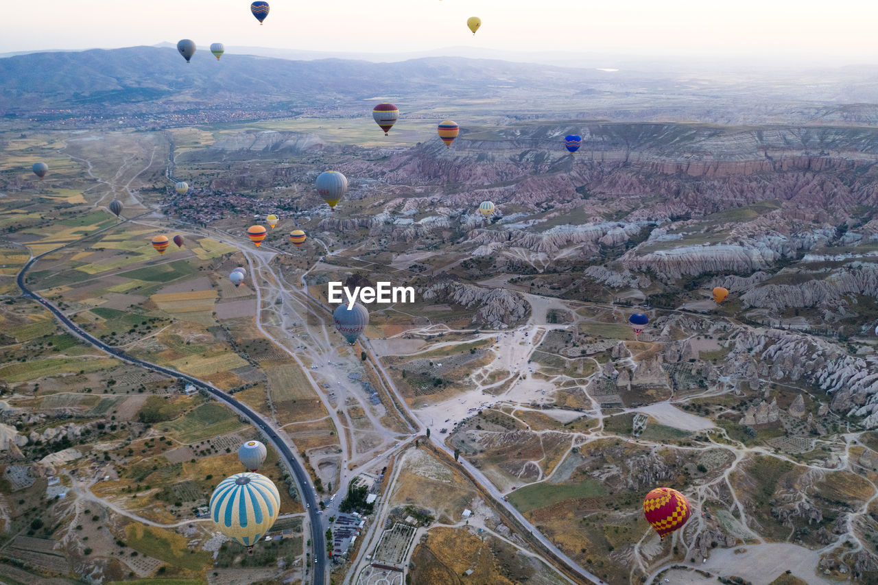 HIGH ANGLE VIEW OF HOT AIR BALLOON FLYING OVER LANDSCAPE