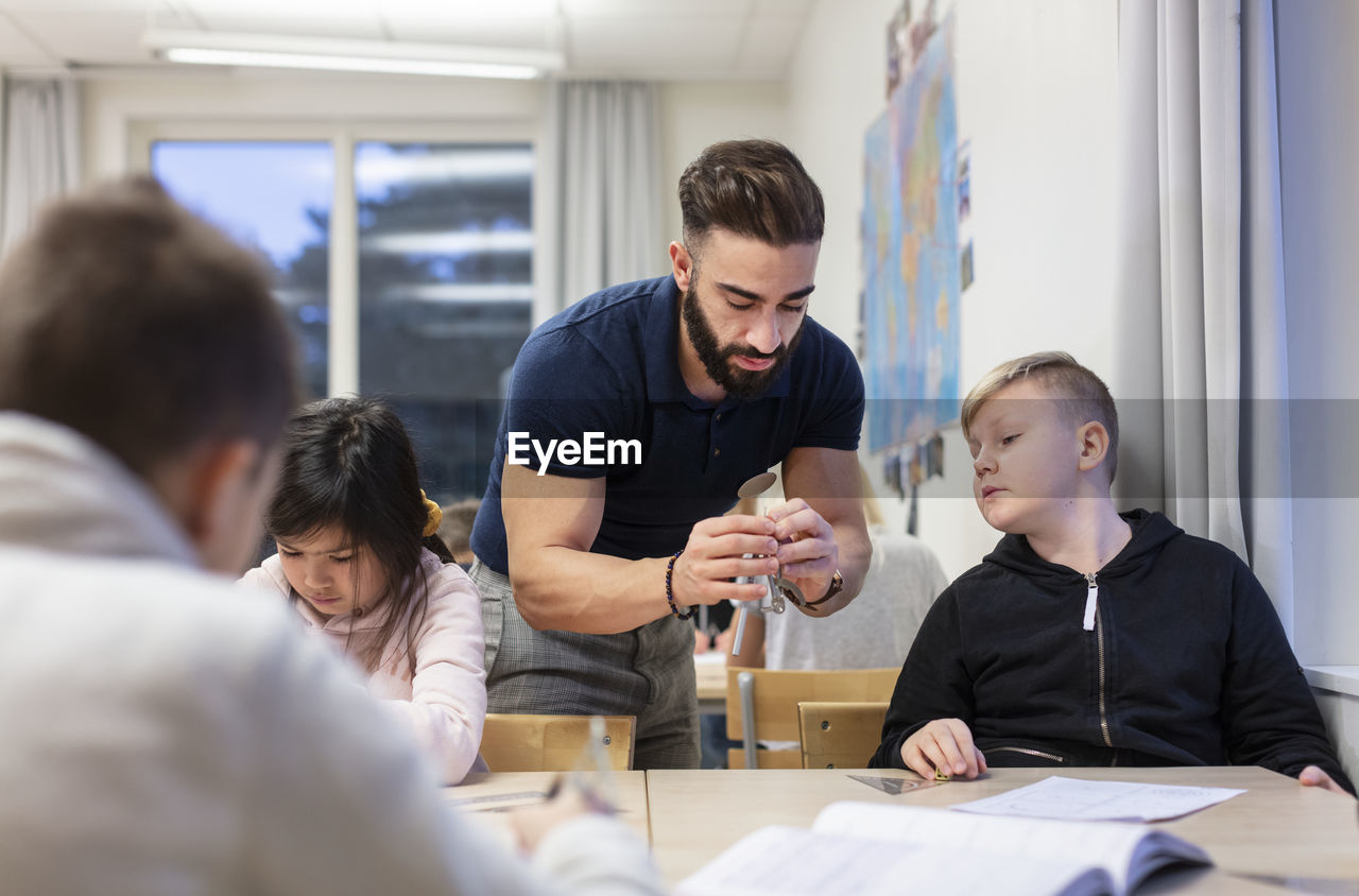 Teacher with schoolboy in classroom