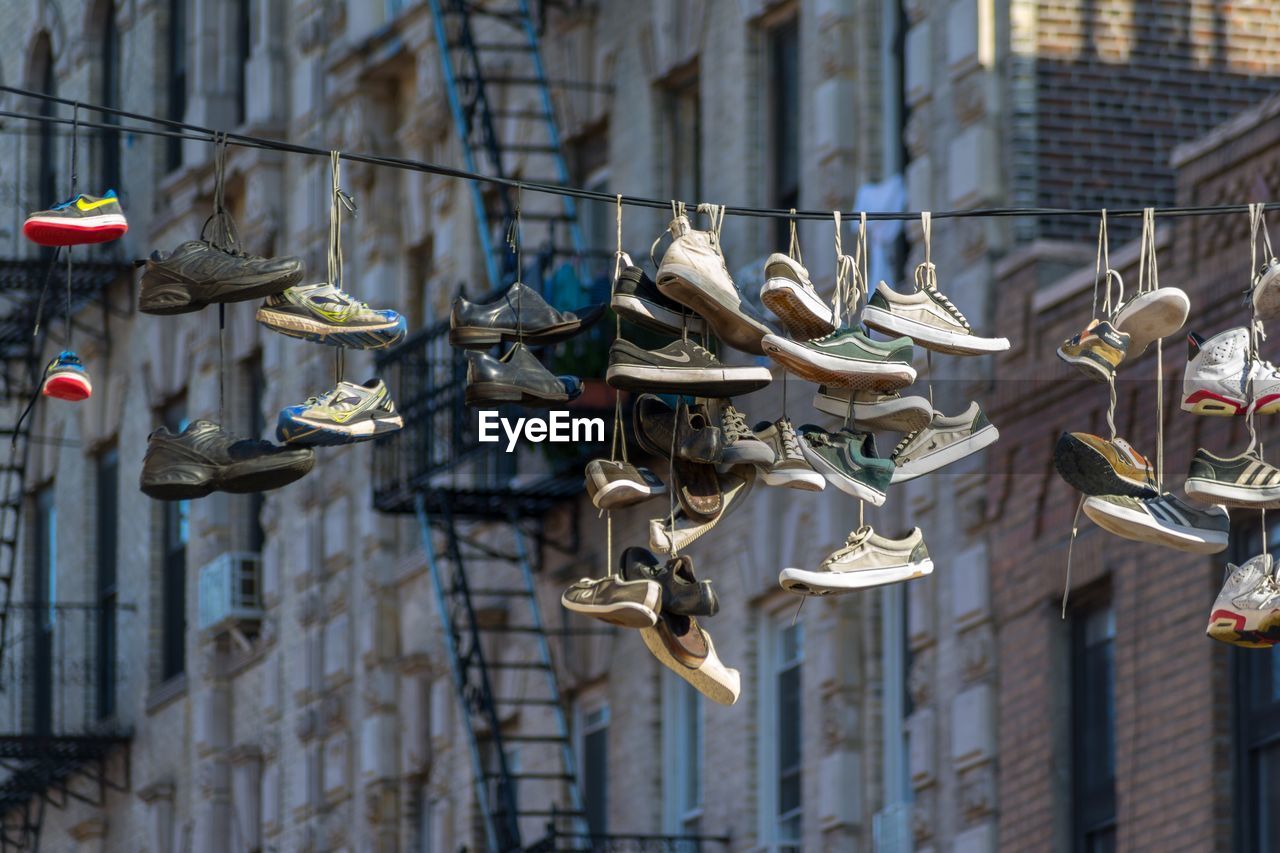 CLOSE-UP OF SHOES HANGING OUTDOORS