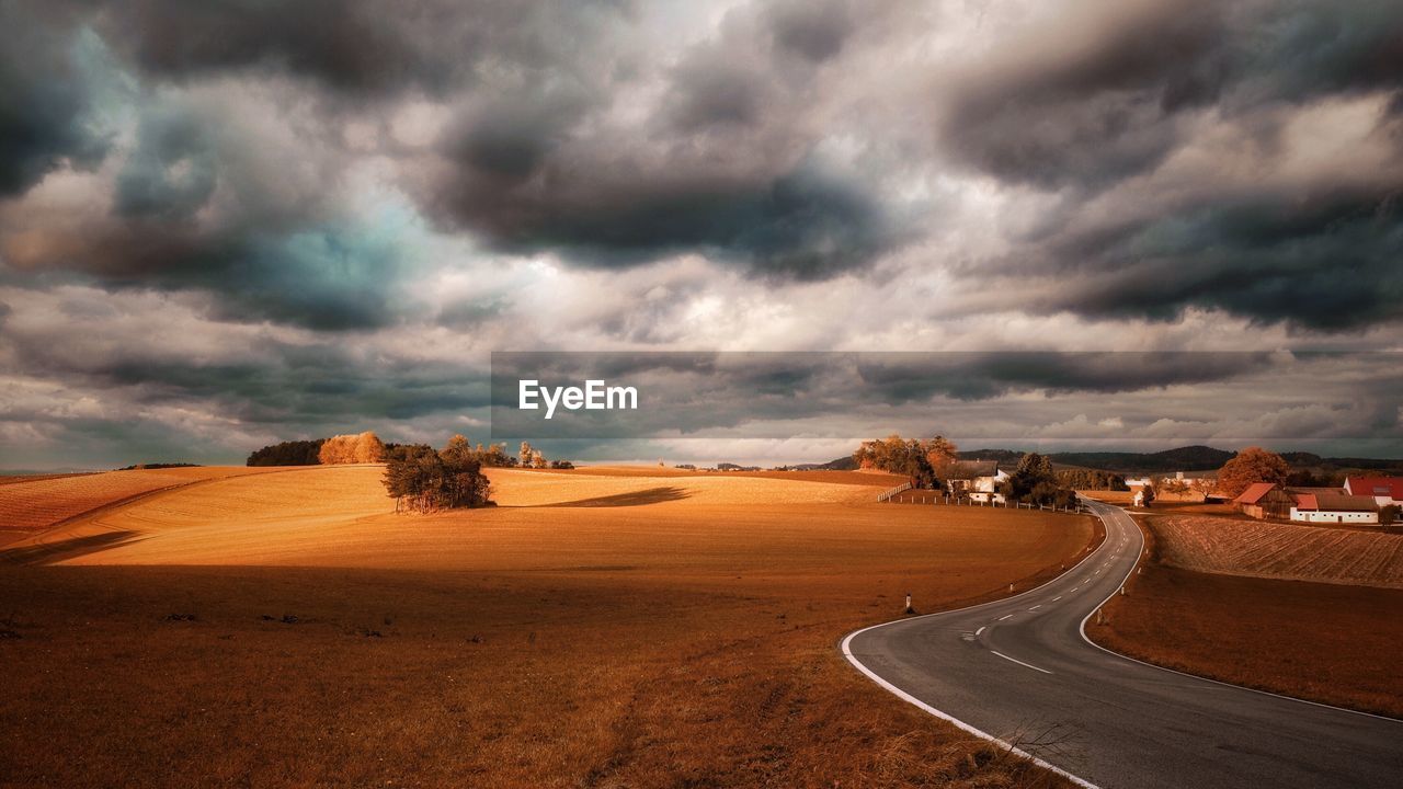 Road in desert against cloudy sky