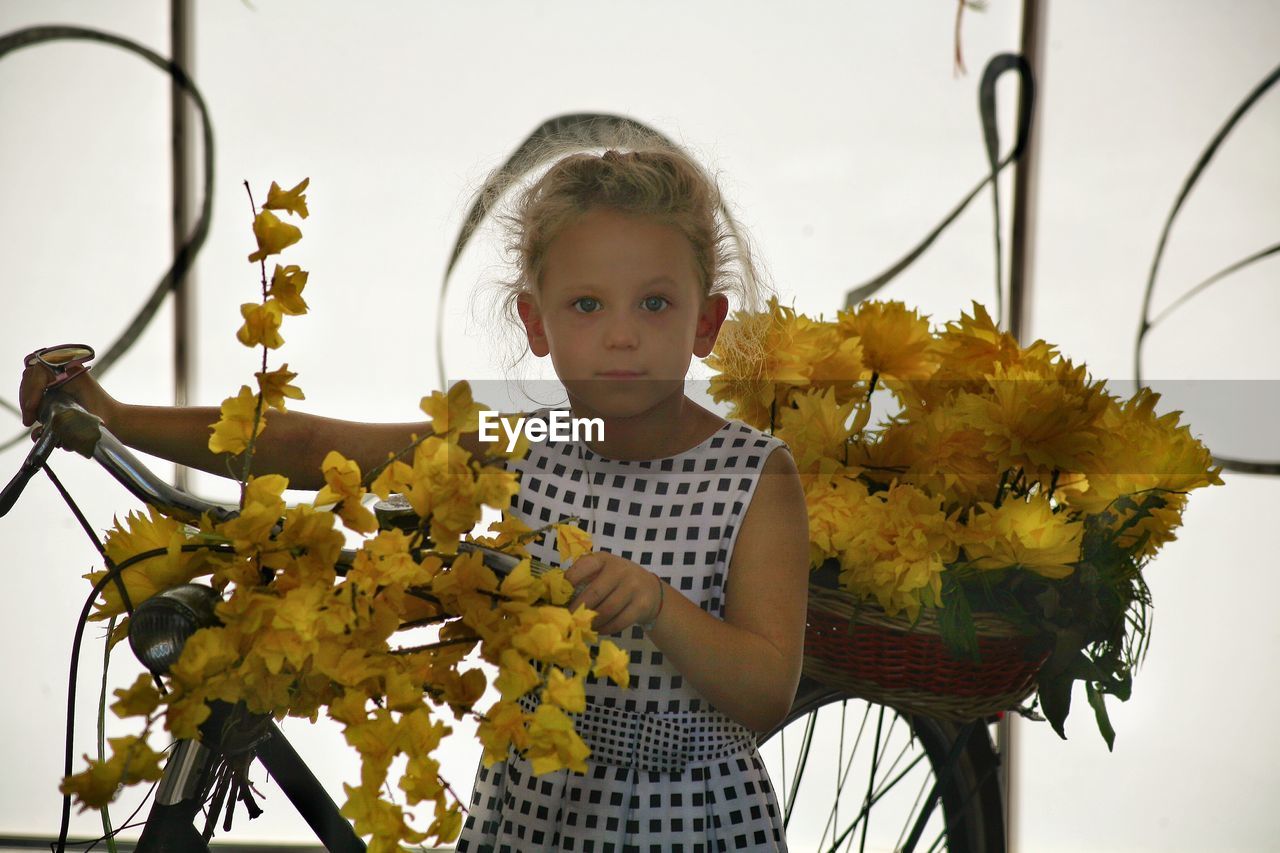 PORTRAIT OF A YOUNG WOMAN HOLDING FLOWER