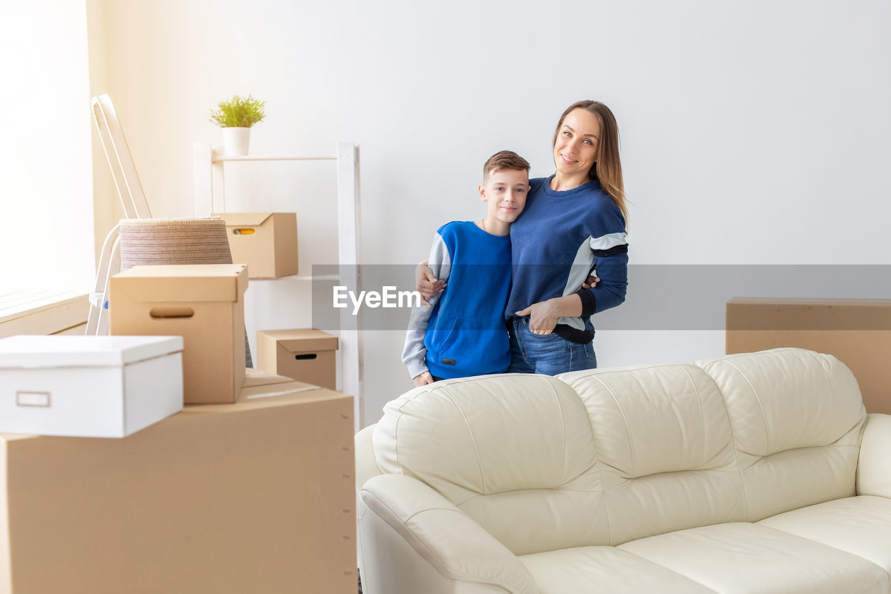 Portrait of mother and son standing at home