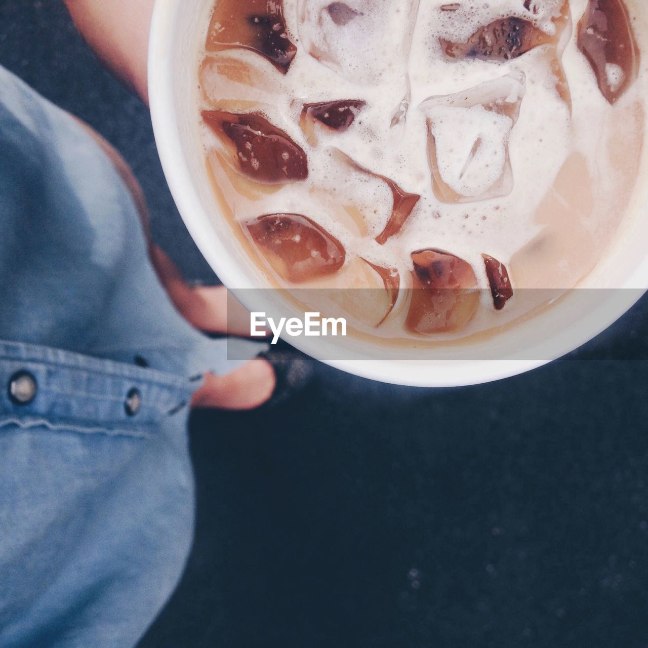 Low section of woman holding iced coffee