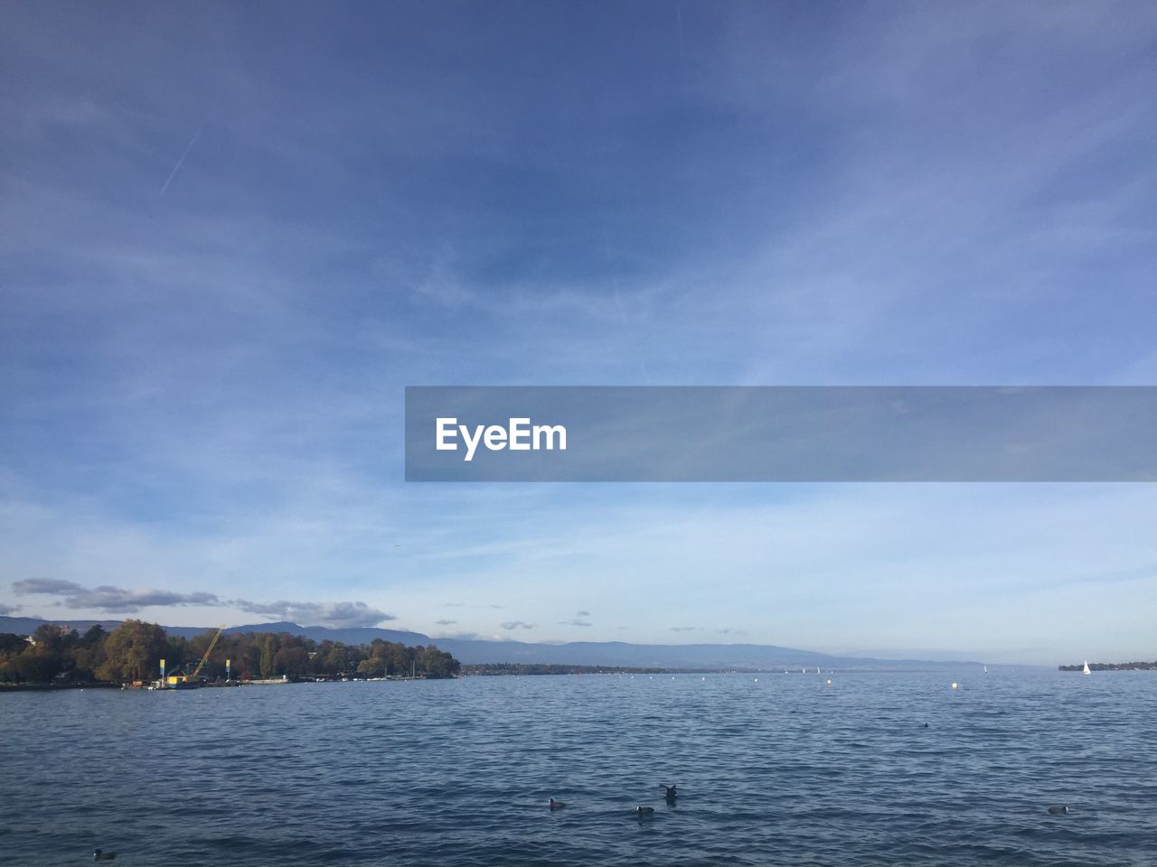 SCENIC VIEW OF SEA BY MOUNTAINS AGAINST SKY