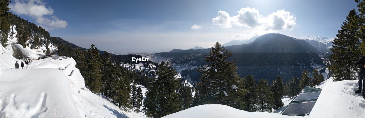 PANORAMIC SHOT OF SNOW COVERED MOUNTAINS AGAINST SKY