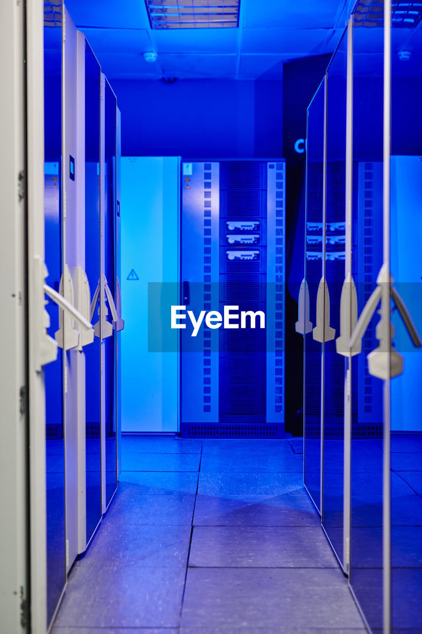 Corridor of illuminated server room with blue neon light