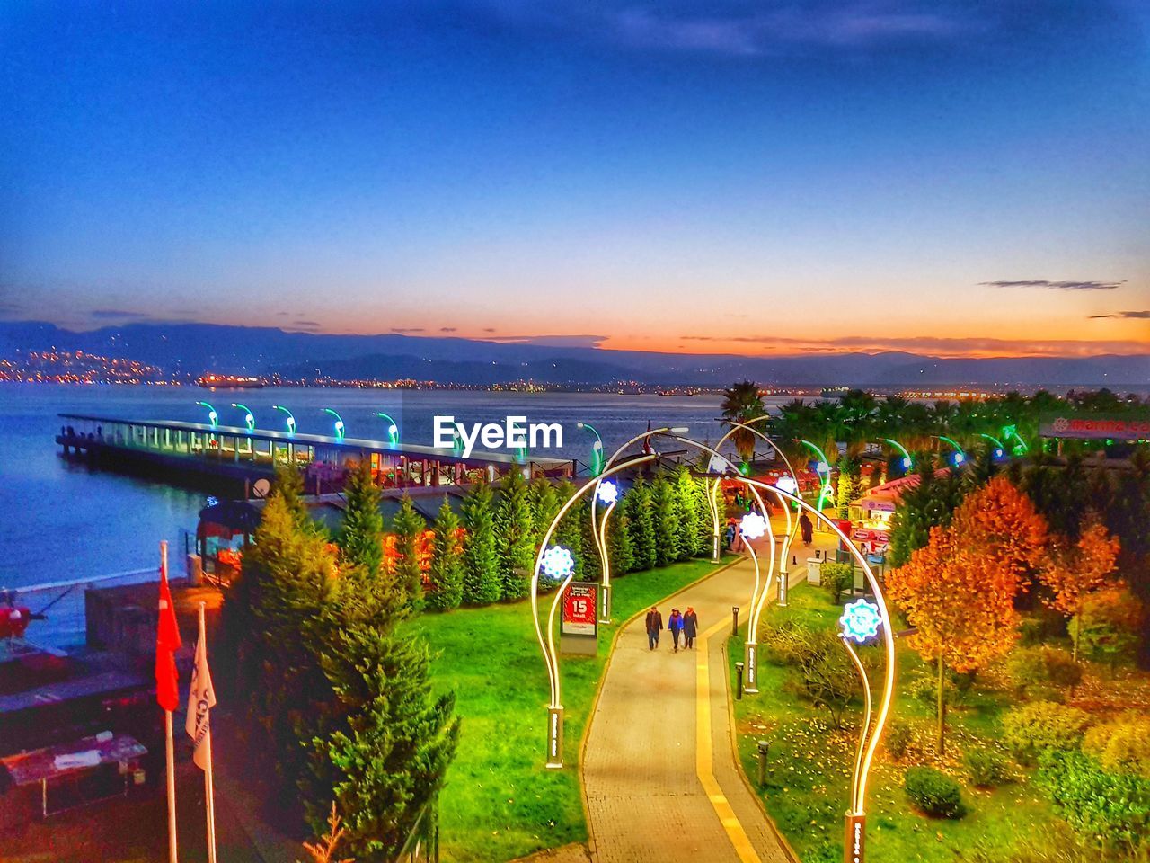 PANORAMIC VIEW OF ILLUMINATED PARK AGAINST BLUE SKY