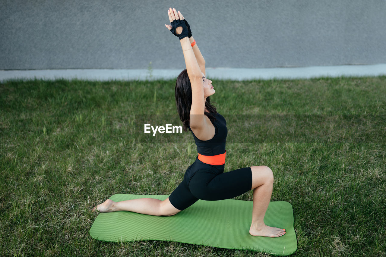 Fitness training, a beautiful middle-aged girl doing stretching outdoors. yoga