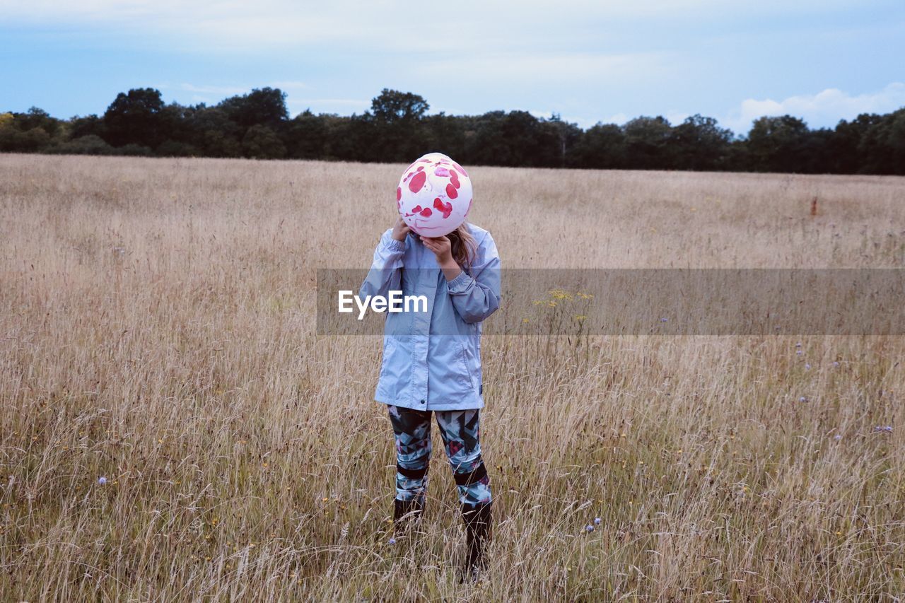 GIRL STANDING ON FIELD