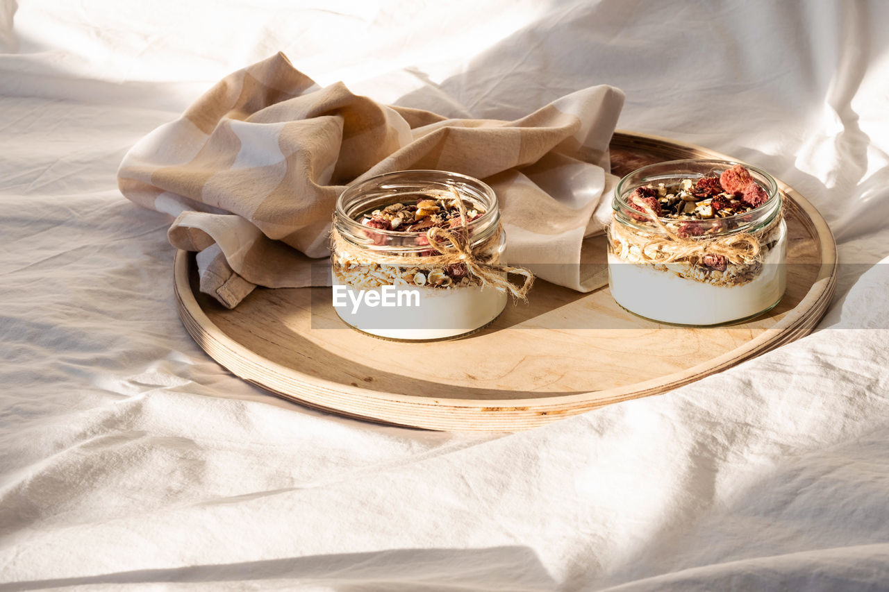 Quick healthy breakfast greek yogurt, granola with dried berries and nuts in glass jar.