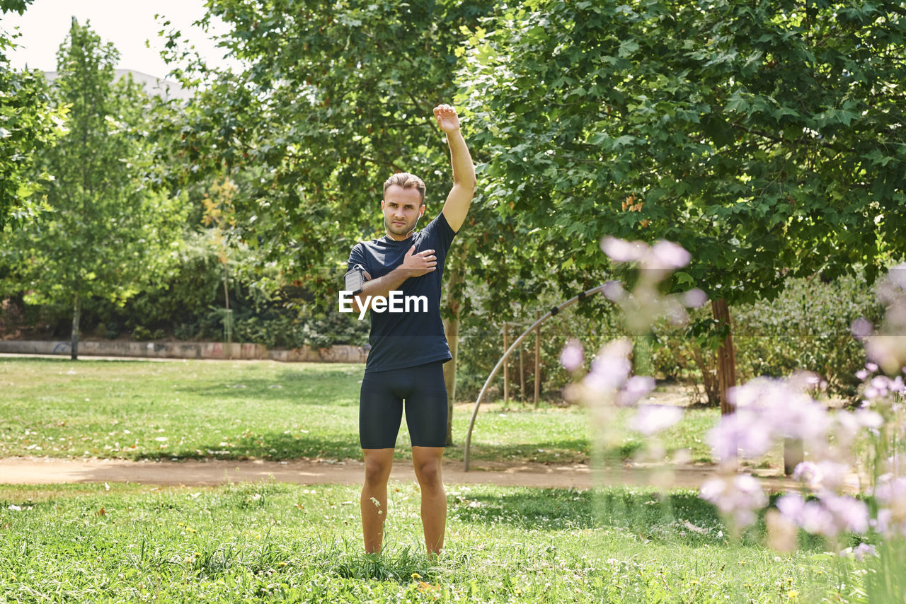 Sportsman stretching arms after training. he is in a park. healthy and healthy life concept. person