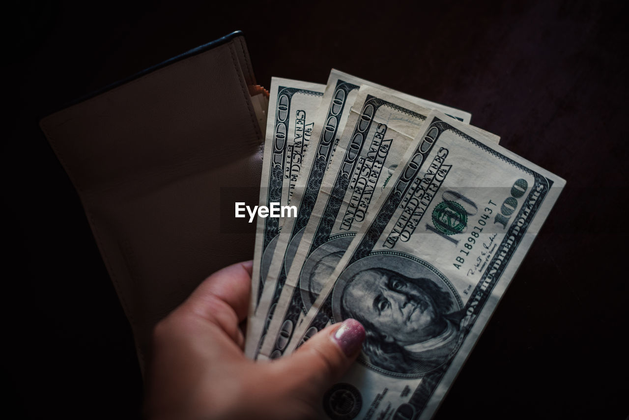 cash, hand, money, paper currency, currency, finance, wealth, business, dollar, holding, one person, black background, indoors, studio shot, adult, close-up, business finance and industry