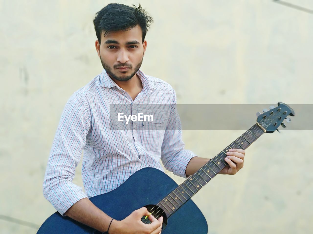 Portrait of young man playing guitar