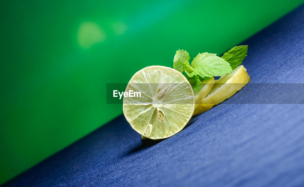 green, lemon, food and drink, fruit, yellow, citrus fruit, macro photography, leaf, close-up, food, healthy eating, lime, freshness, wellbeing, citrus, slice, no people, plant, indoors, produce, plant part, flower, still life, nature, studio shot, table, copy space, colored background