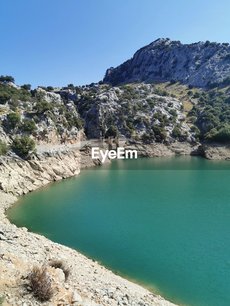 Scenic view of sea and rocks against blue sky