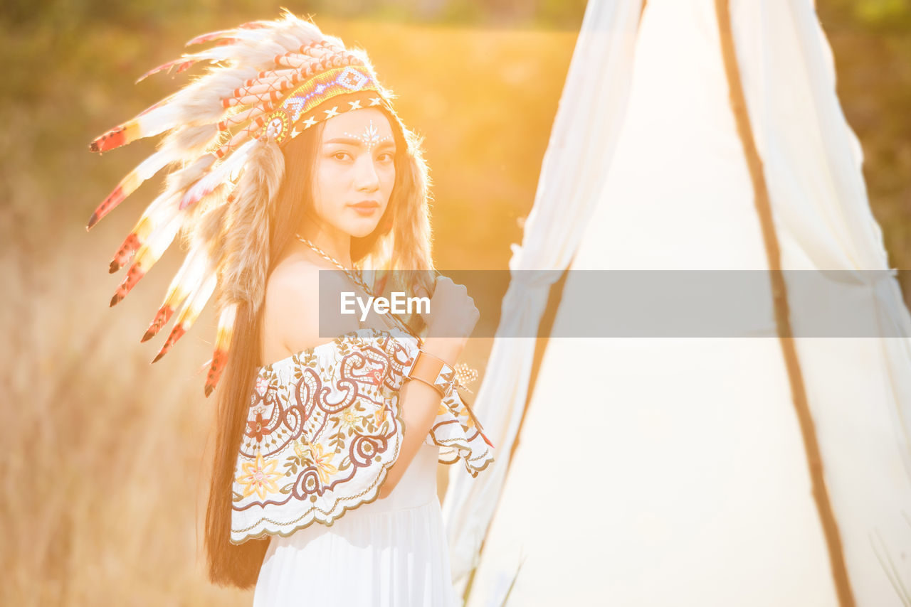 Boho bohemian girl styled wearing indian maxi dress and jewellery in autumn field