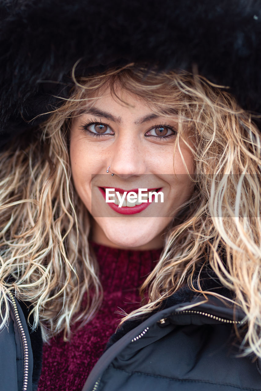 Close-up portrait of smiling young woman with blond hair