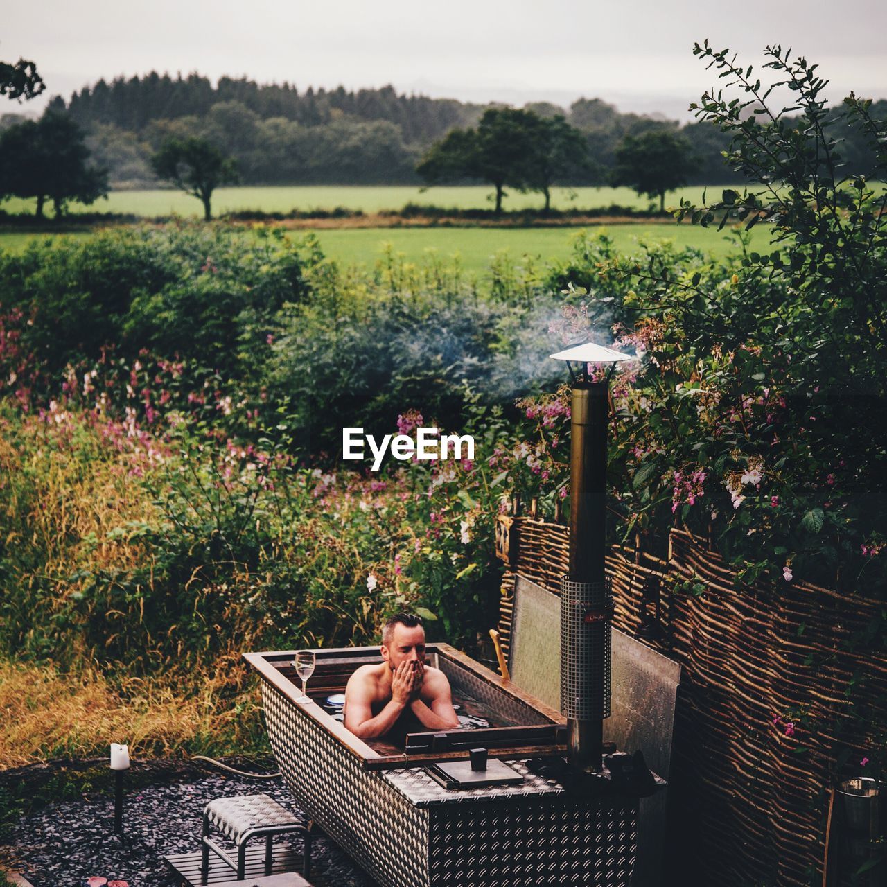 Man bathing in bathtub at front or back yard