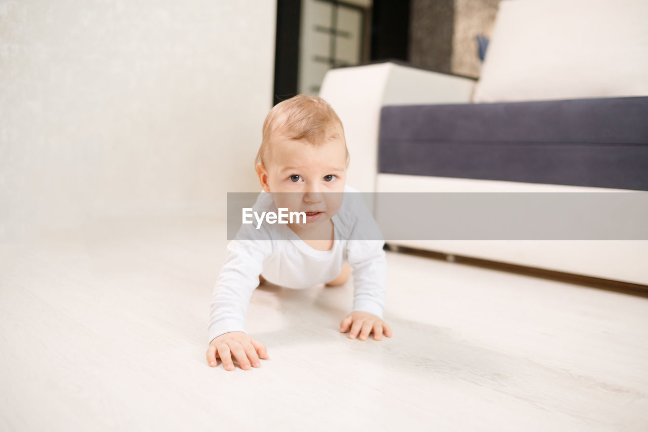 Portrait of cute baby crawling at home