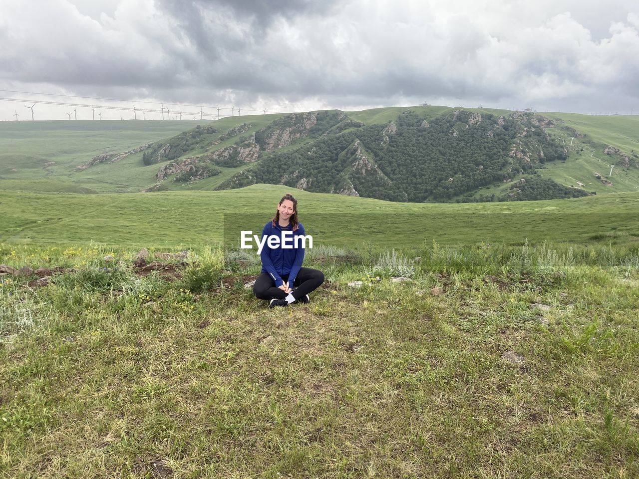 Full length of young woman sitting on field
