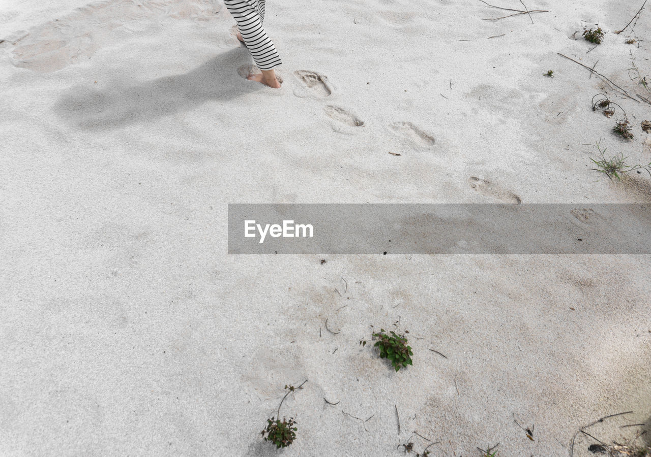 HIGH ANGLE VIEW OF FOOTPRINTS ON SAND AT BEACH