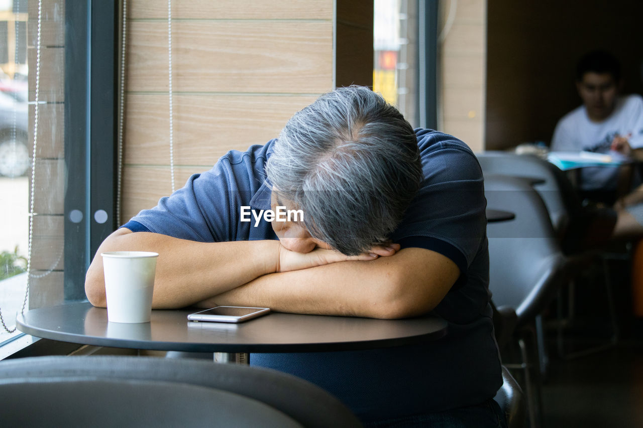 MAN SITTING ON TABLE WITH COFFEE