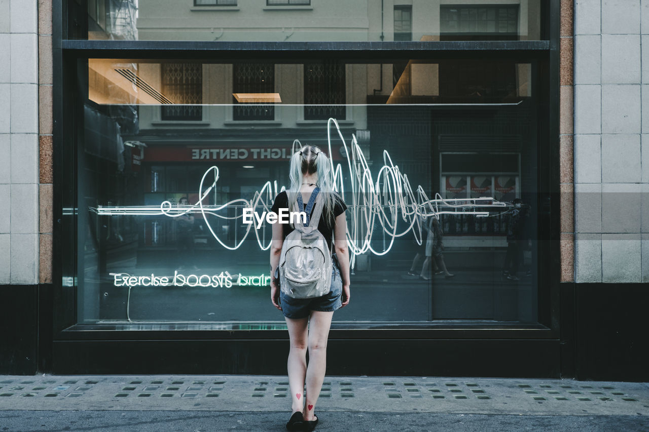 FULL LENGTH OF WOMAN STANDING OUTSIDE BUILDING