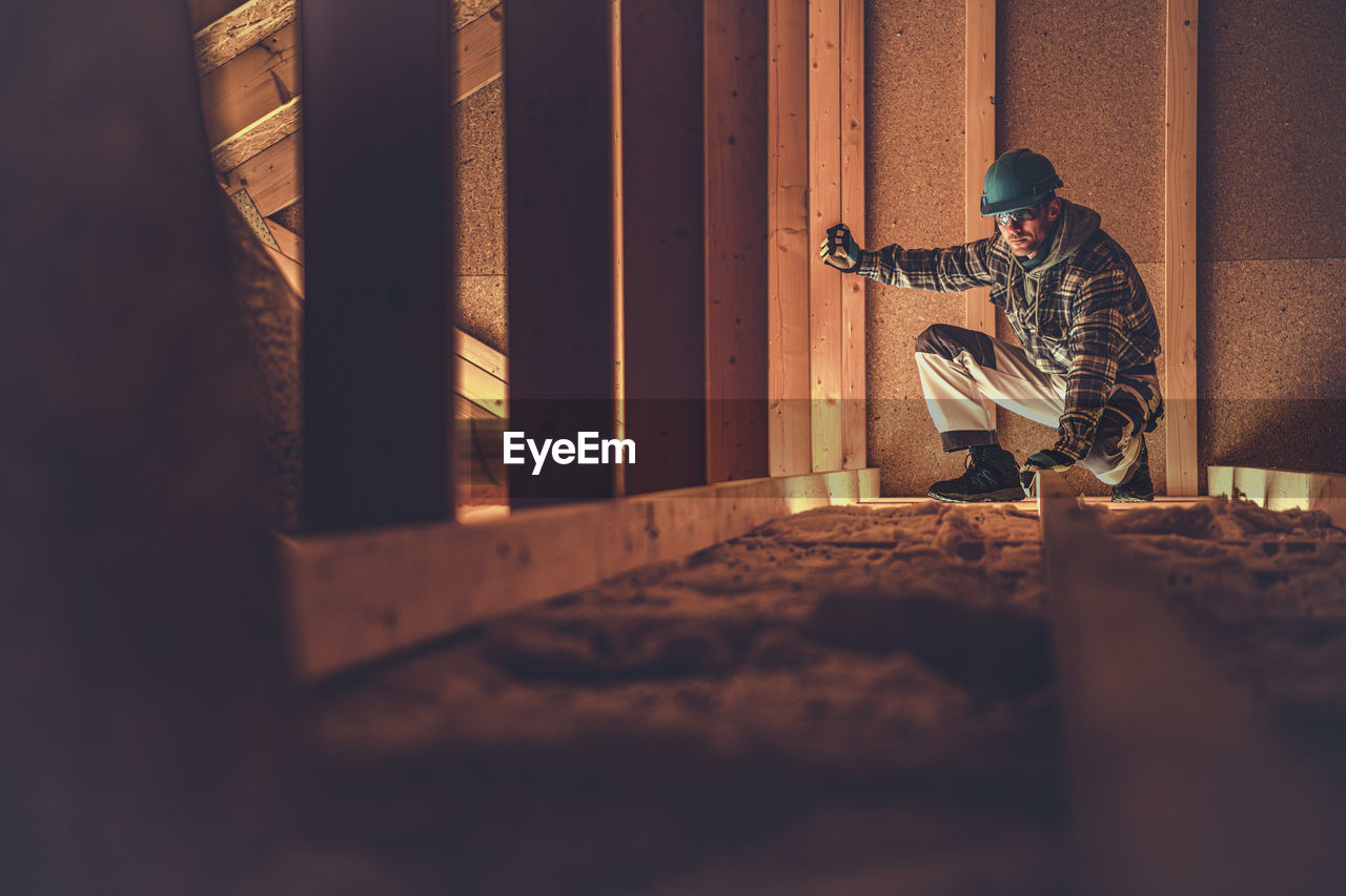 Full length of carpenter working at construction site