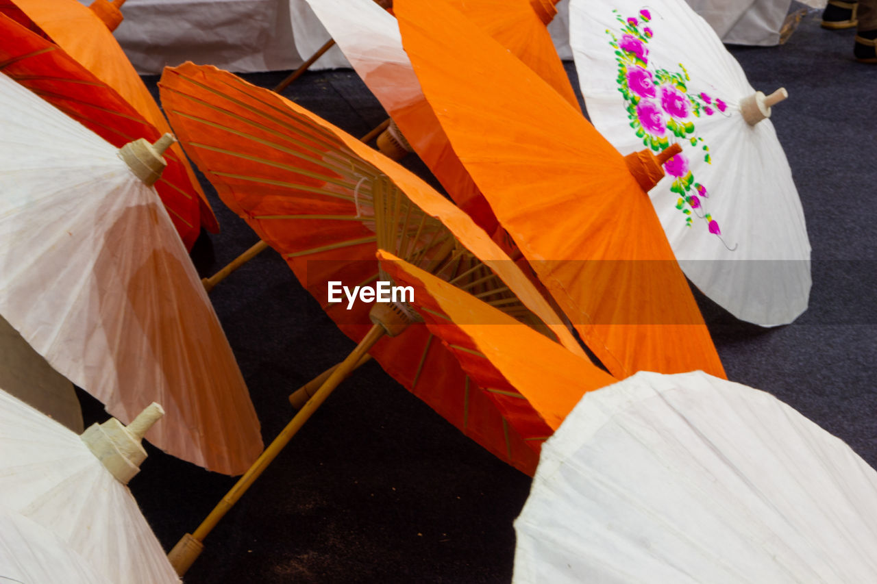 HIGH ANGLE VIEW OF MULTI COLORED UMBRELLAS ON CROSS