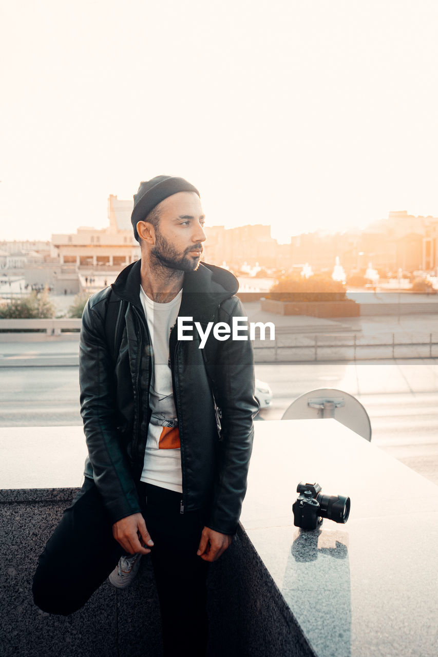 Young man looking at camera against sky