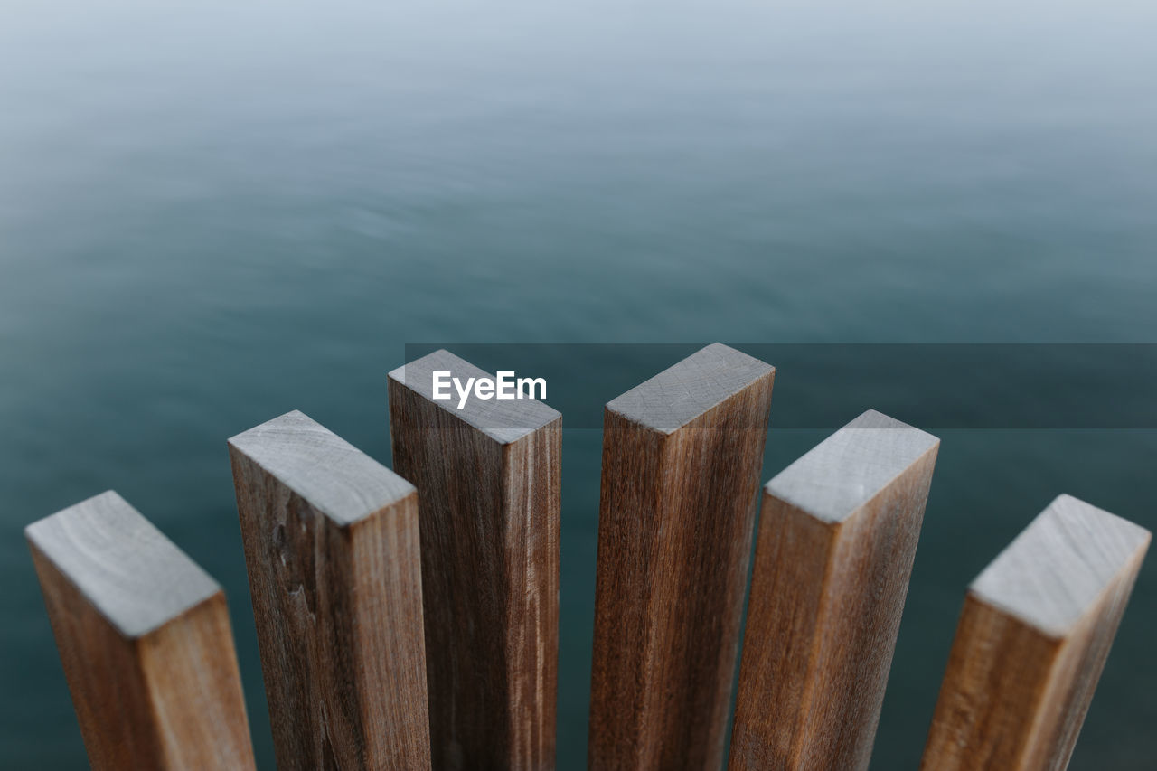 High angle of modern wooden beams placed near pond with calm water at daytime