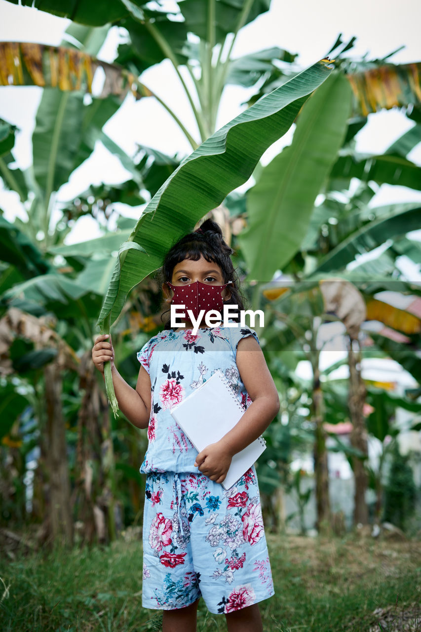 FULL LENGTH OF GIRL STANDING BY TREE