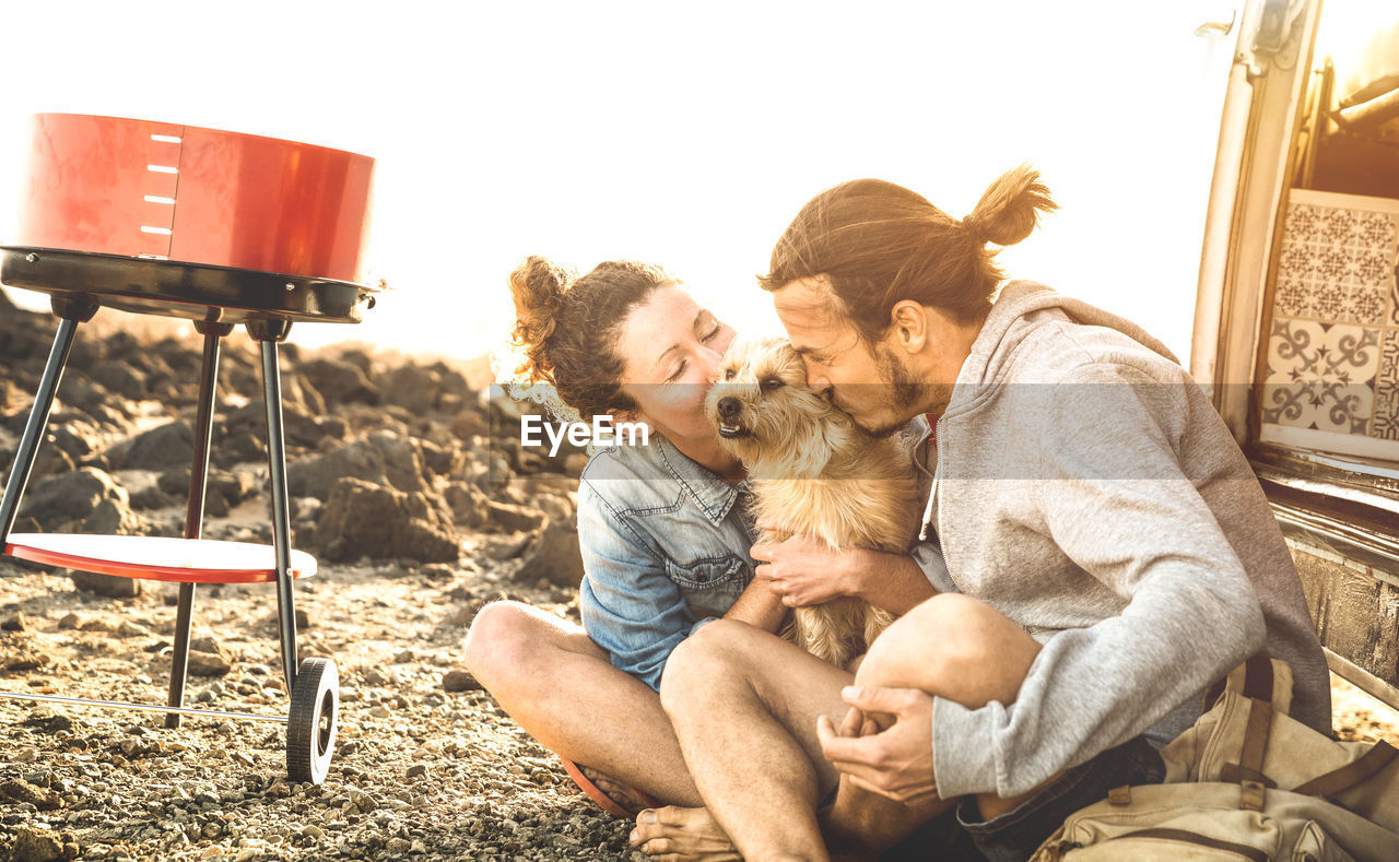 Couple with dog sitting on field