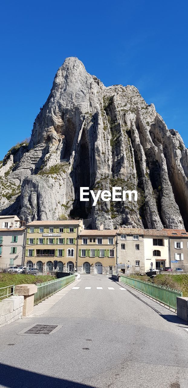 ROAD BY MOUNTAIN AGAINST CLEAR BLUE SKY