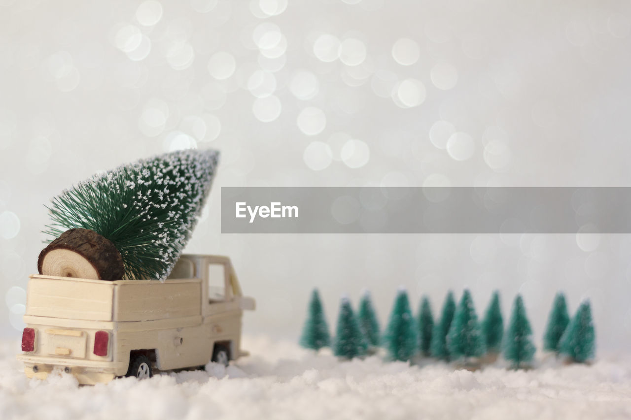 Rear view of truck with christmas tree on snowy background with copy space