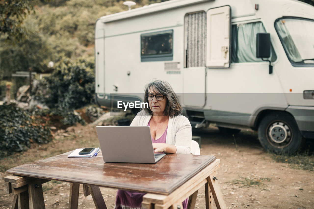 Woman using laptop while sitting at table