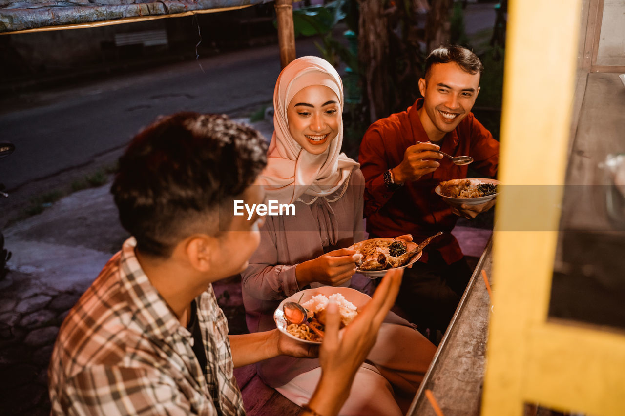Smiling people having food at stall