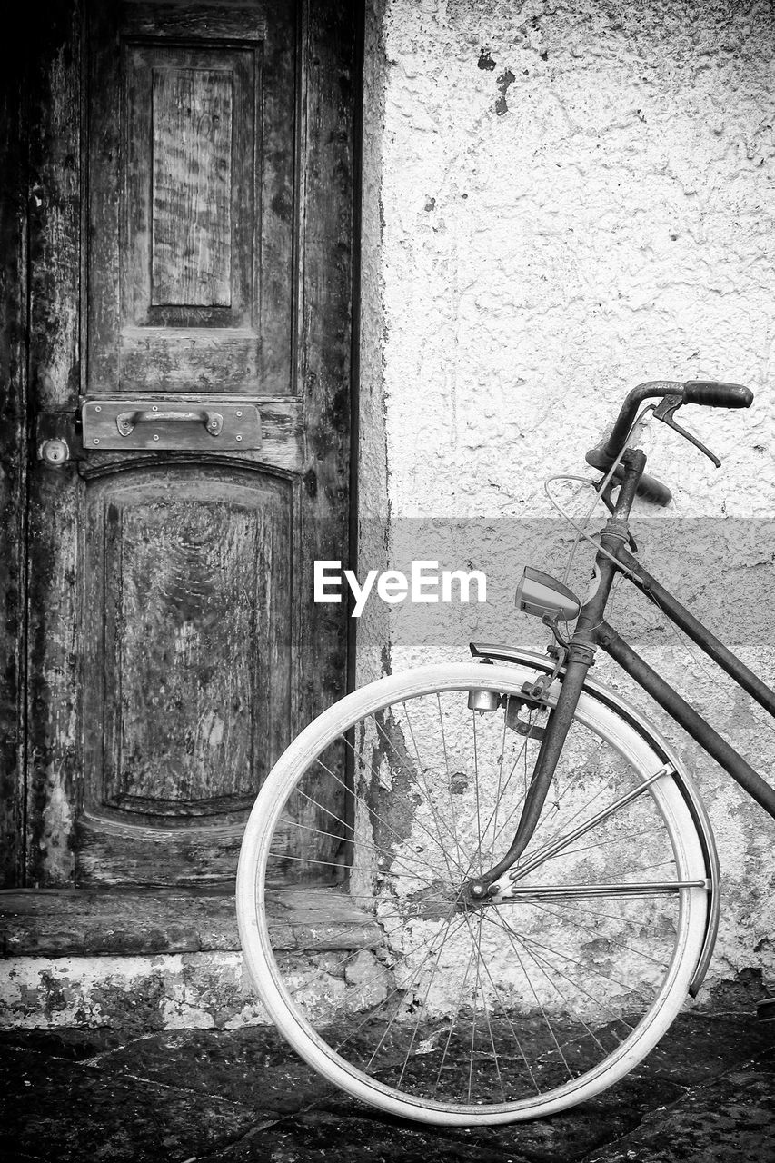 Old doors and wall with vintage bike, black and white shot.