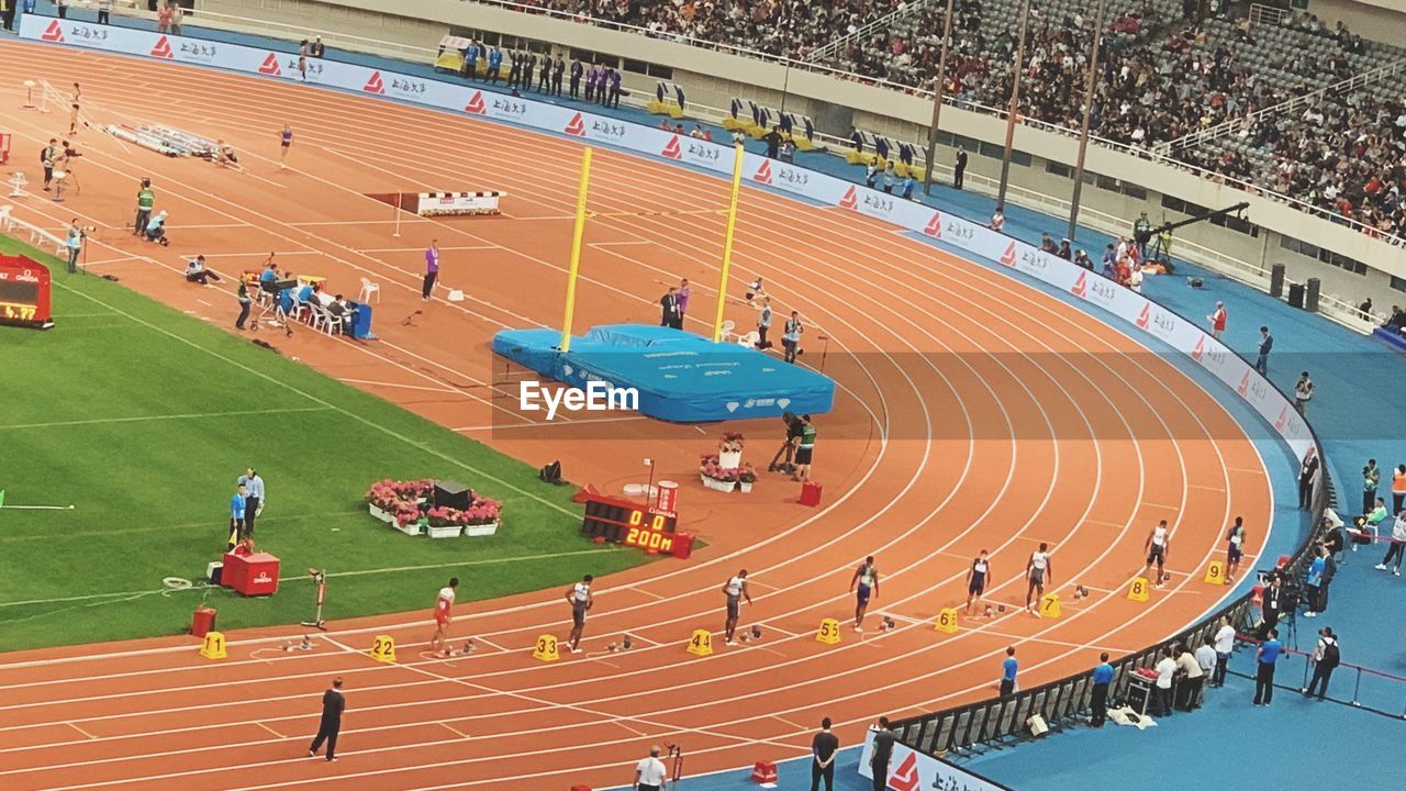 HIGH ANGLE VIEW OF PEOPLE RUNNING ON STADIUM