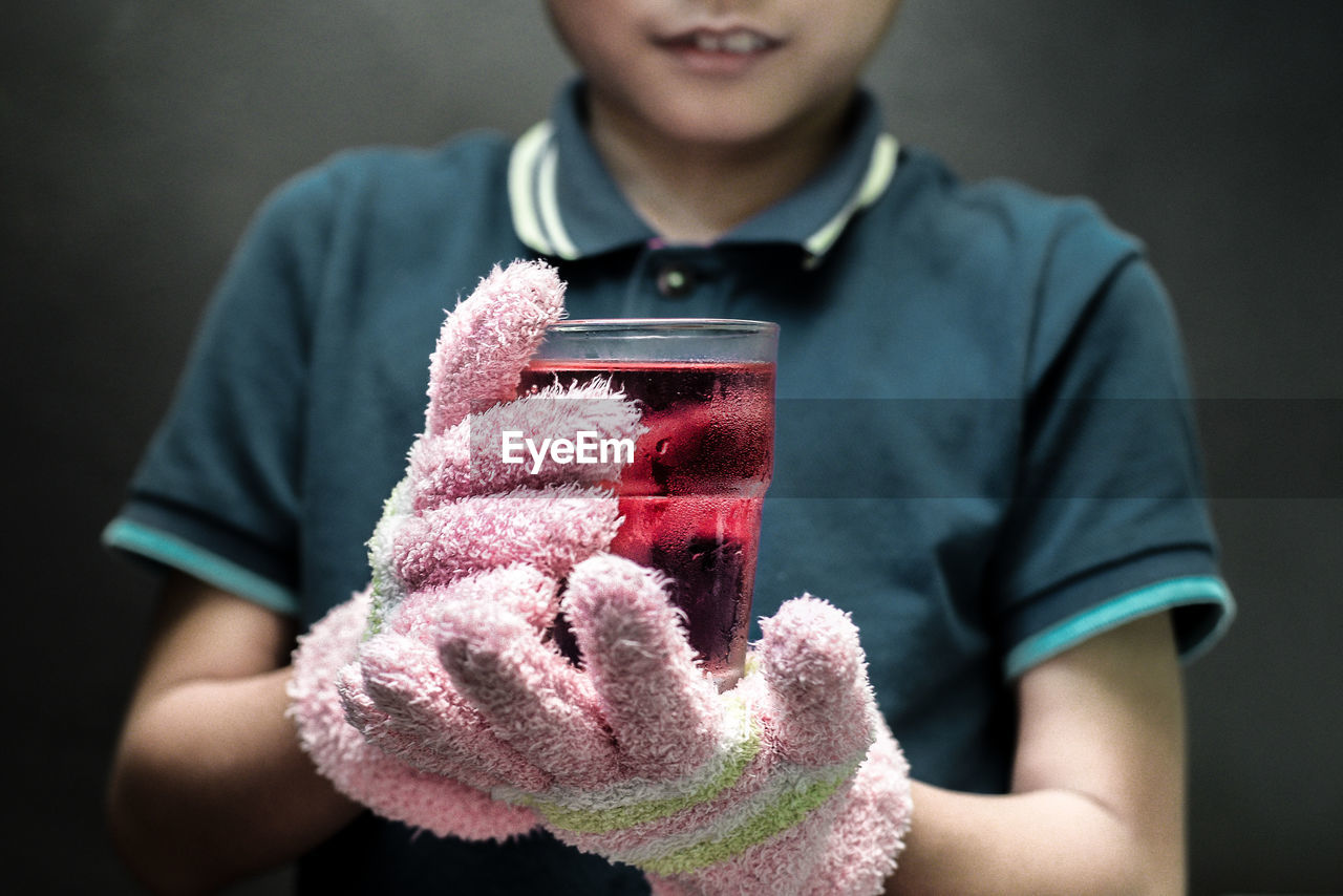 Close-up of boy holding cold juice drink