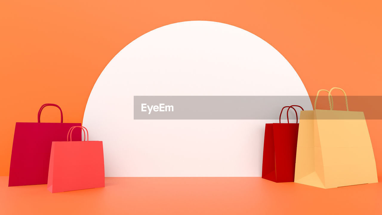 LOW ANGLE VIEW OF RED PAPER AGAINST ORANGE BACKGROUND