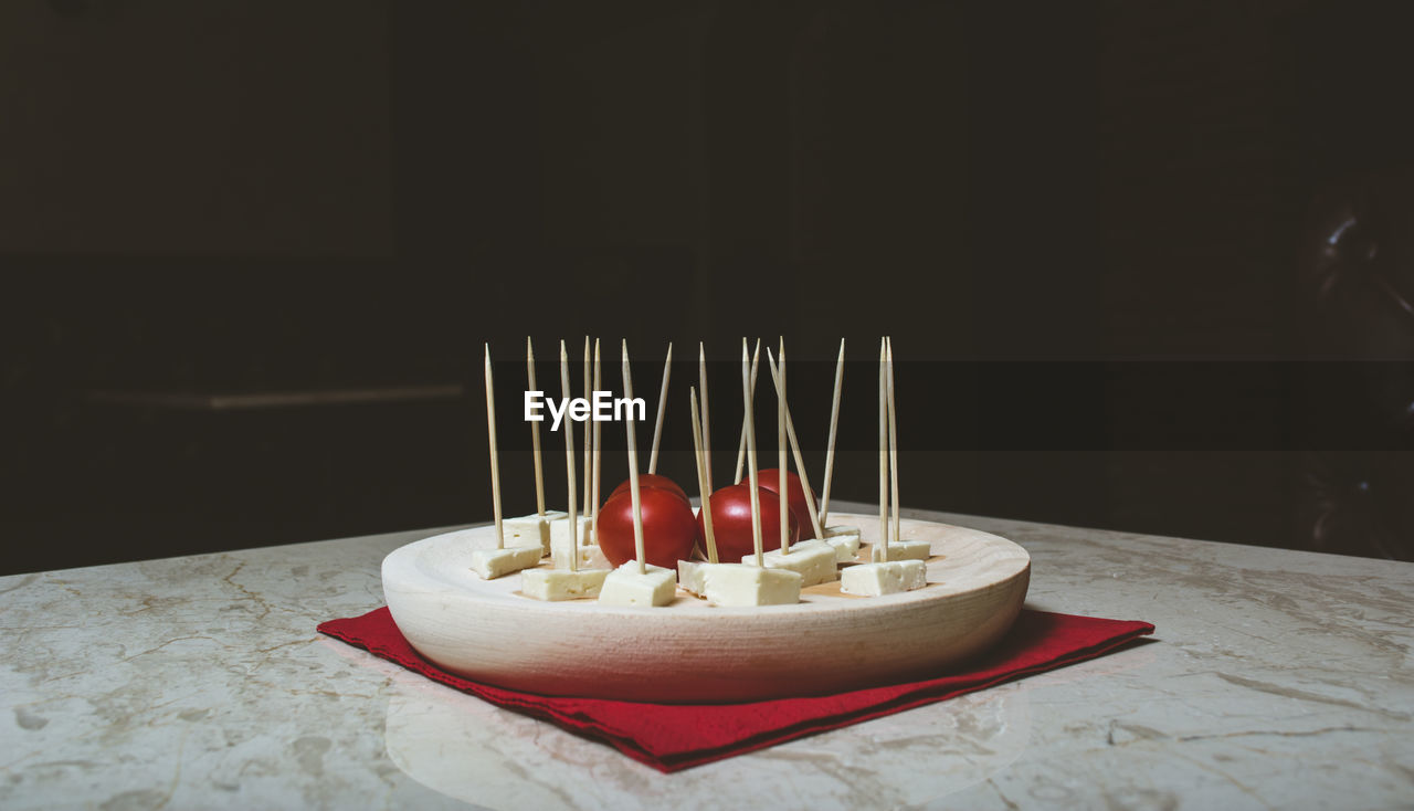 Close-up of cheese and cherry tomatoes in plate on table