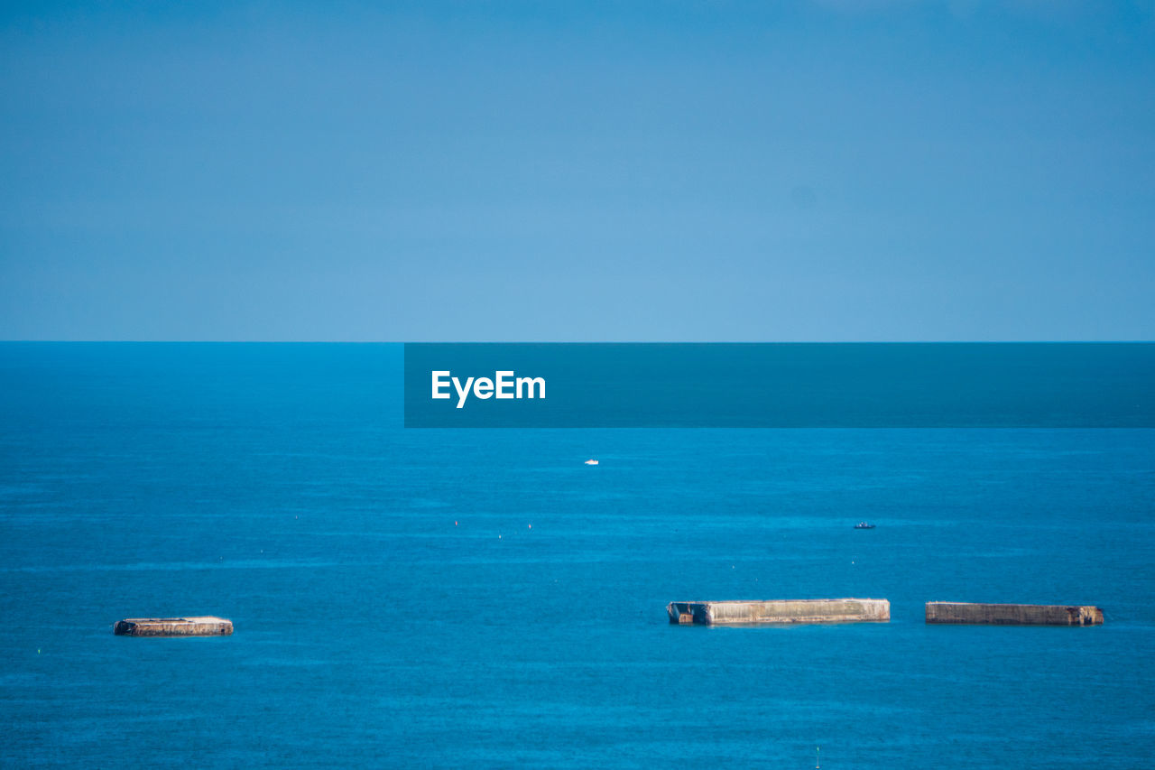 Scenic view of blue sea and mulberry against clear sky