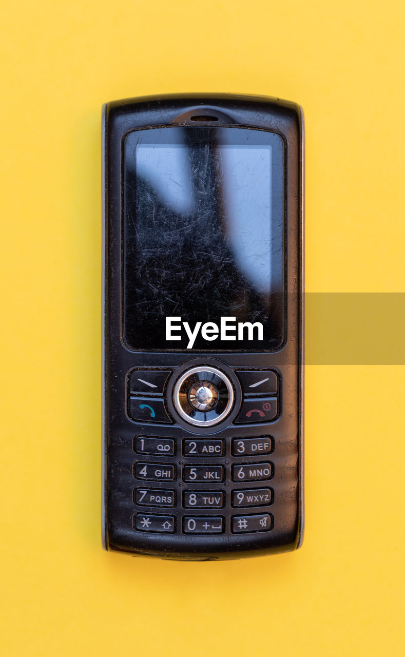 CLOSE-UP OF TELEPHONE ON YELLOW BACKGROUND