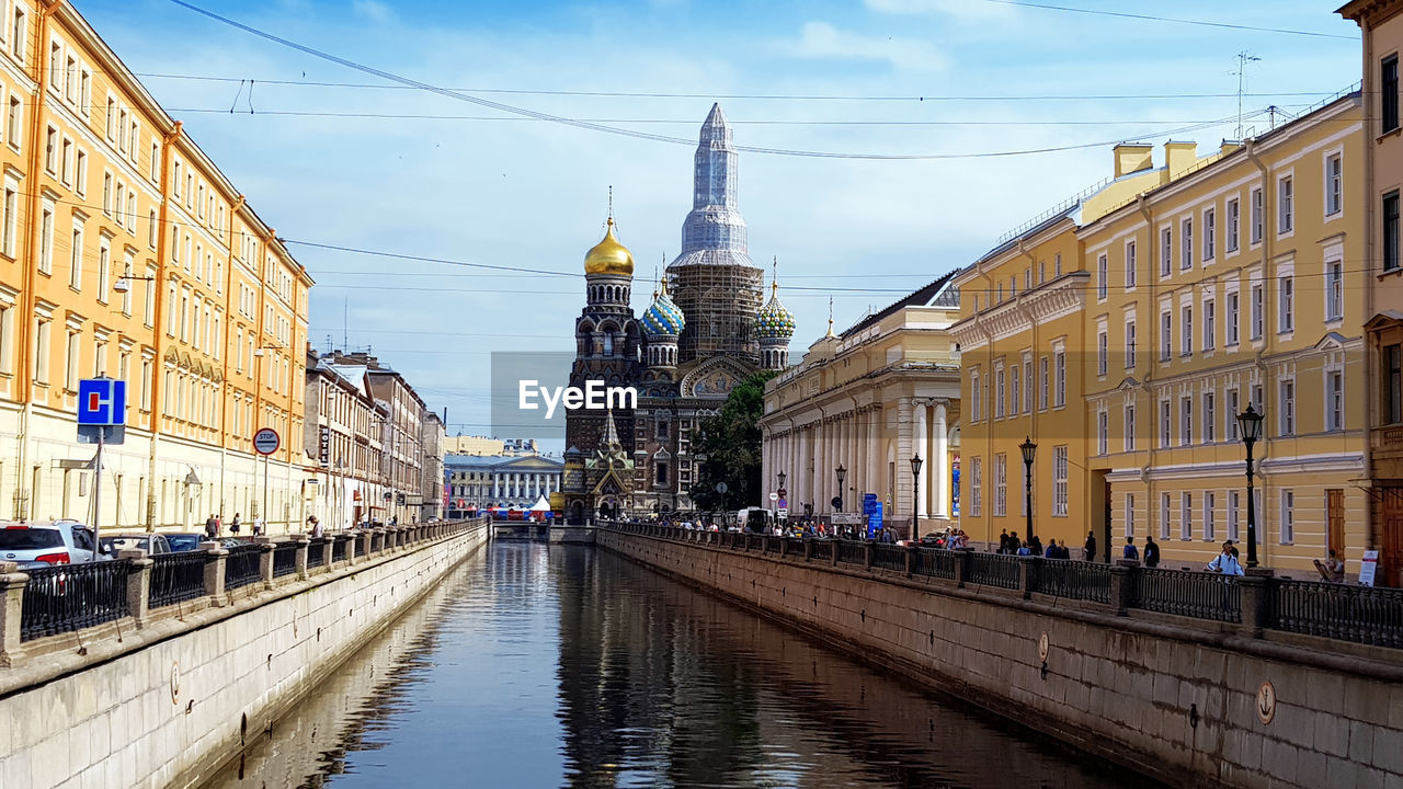 PANORAMIC VIEW OF CANAL AMIDST BUILDINGS IN CITY