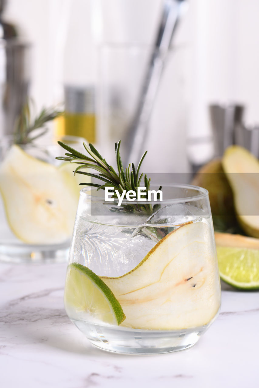 Gin cocktail with lime, rosemary, ripe pear and tonic. this organic drink 
